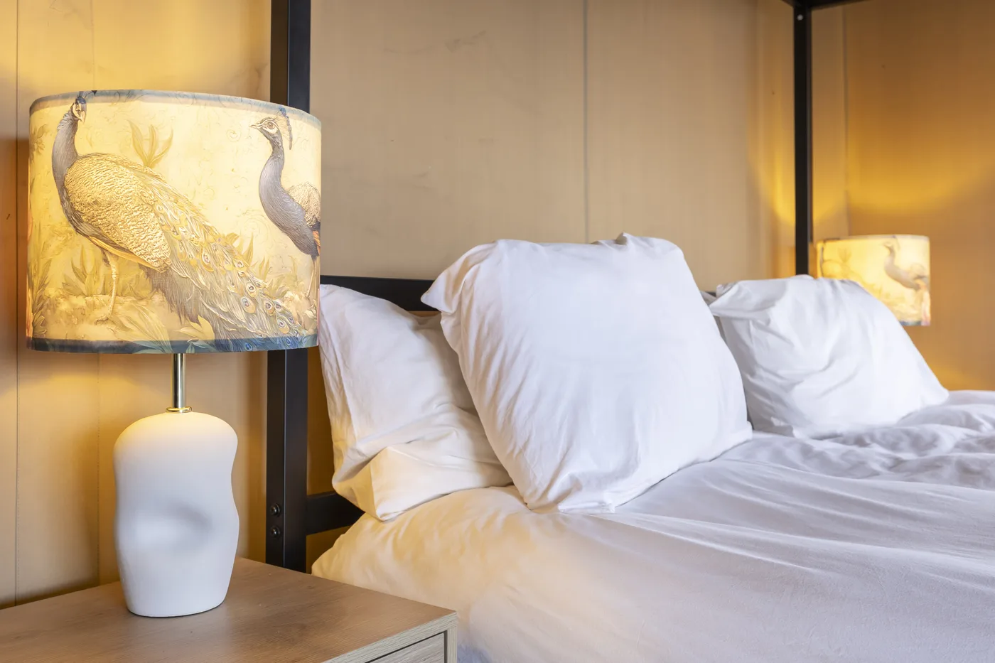 Opgemaakt bed in de Jacuzzi Lodge, warm licht